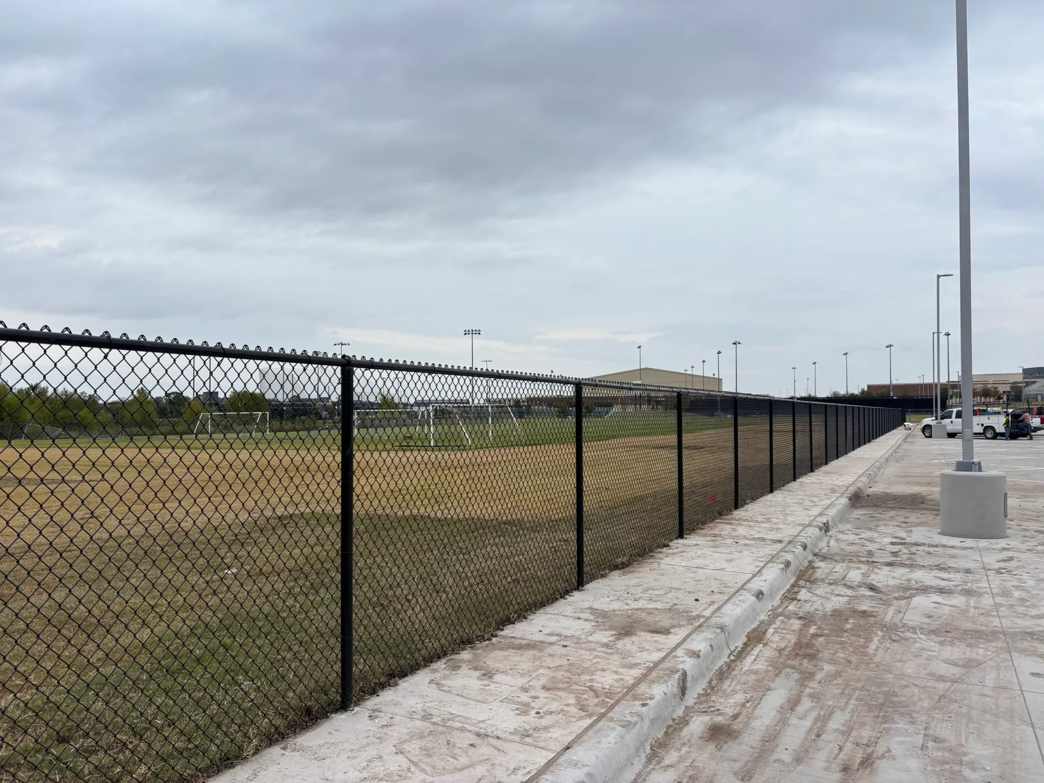 Black vinyl-coated chain link fence around a school yard