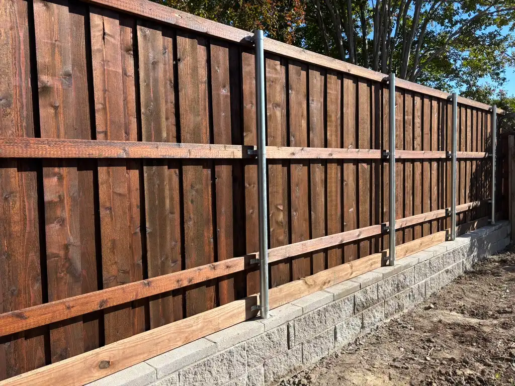 Board-on-board cedar fence built above a block retaining wall