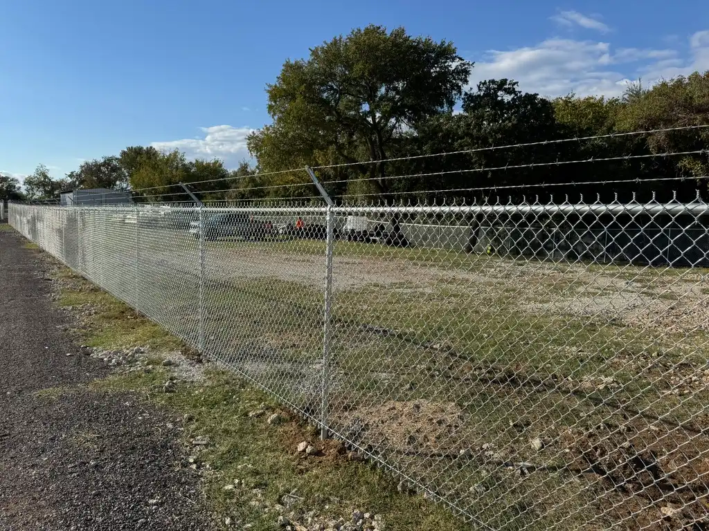 Galvanized chain link fence with barbed wire securing a commercial yard