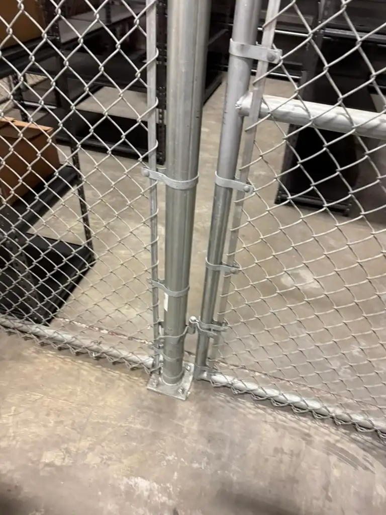 Base-plated commercial chain link fence posts bolted to concrete