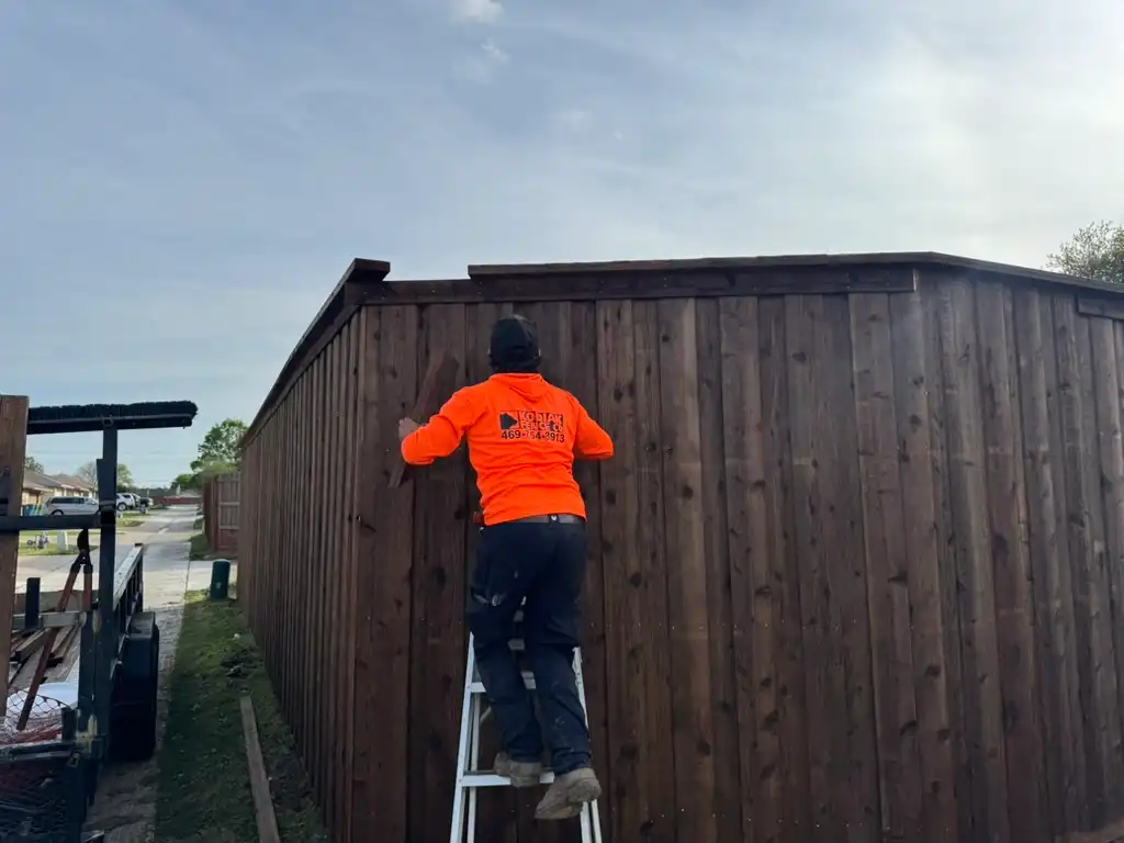 Kodiak installer finishing details on a new fence