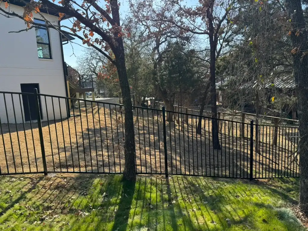 Black iron fence stepped cleanly down a sloped yard