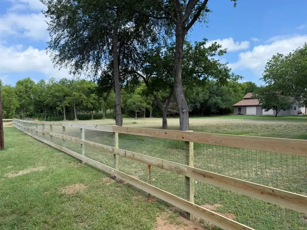 Three rail ranch style fence with no-climb wire backing on acreage
