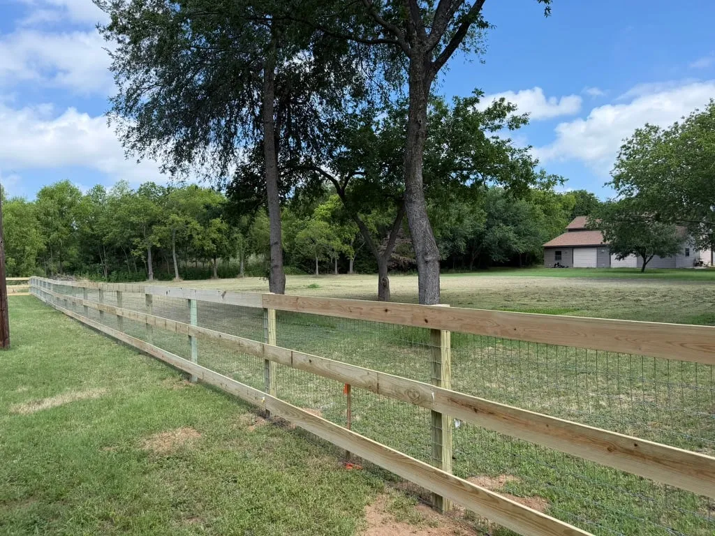 Three rail ranch style fence with no-climb wire backing on acreage
