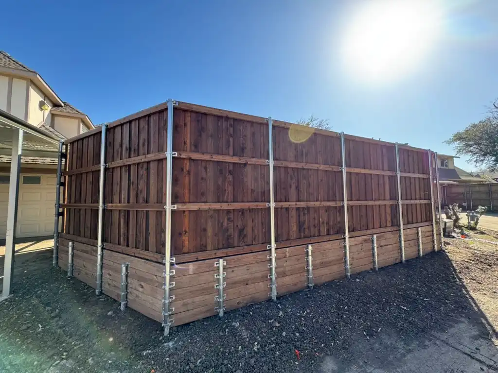 Cedar privacy fence built above a wood retaining wall